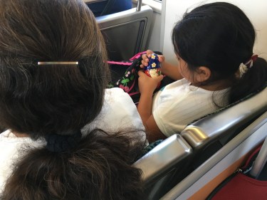 Little girls with nesting dolls on train